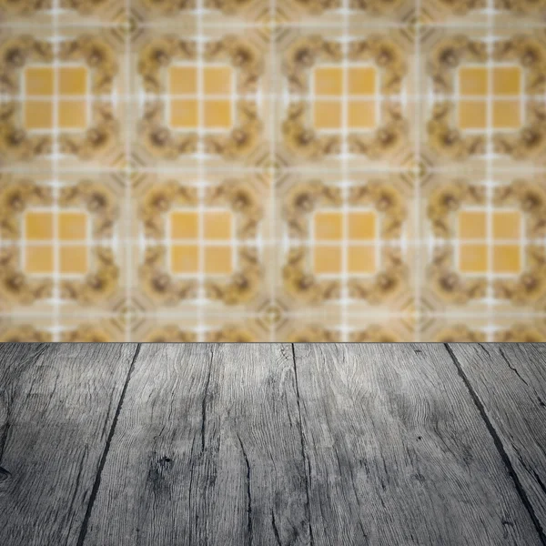 Wood table top and blur vintage ceramic tile pattern wall — Stock Photo, Image