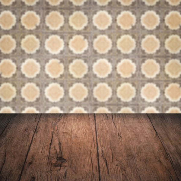 Wood table top and blur vintage ceramic tile pattern wall — Stock Photo, Image