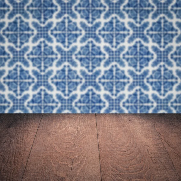 Wood table top and blur vintage ceramic tile pattern wall — Stock Photo, Image