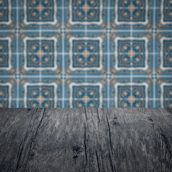 Wood table top and blur vintage ceramic tile pattern wall — Stock Photo, Image