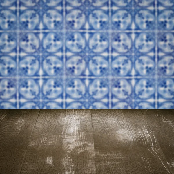 Wood table top and blur vintage ceramic tile pattern wall — Stock Photo, Image