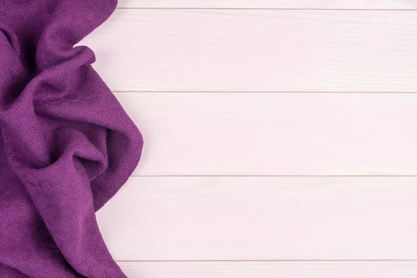 Purple towel over wooden table — Stock Photo, Image
