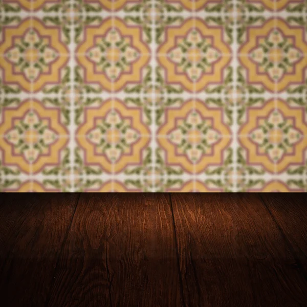 Wood table top and blur vintage ceramic tile pattern wall — Stock Photo, Image