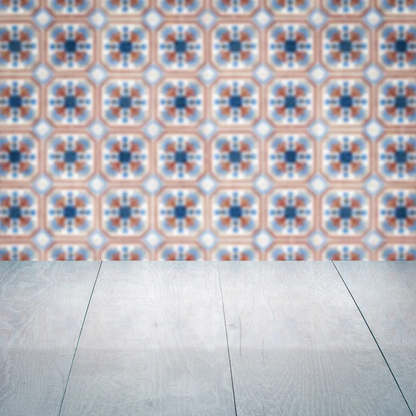 Wood table top and blur vintage ceramic tile pattern wall — Stock Photo, Image