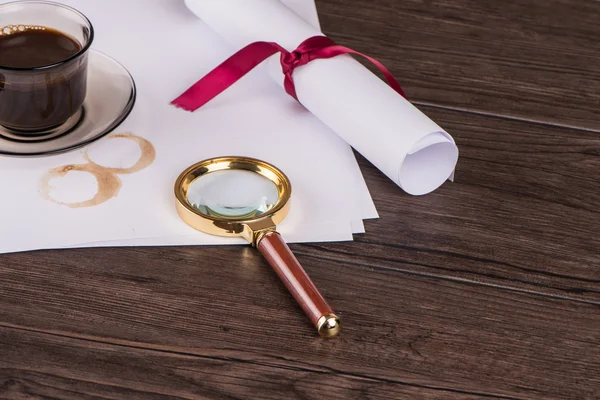 Wrapped paper sheets and magnifying glass — Stock Photo, Image