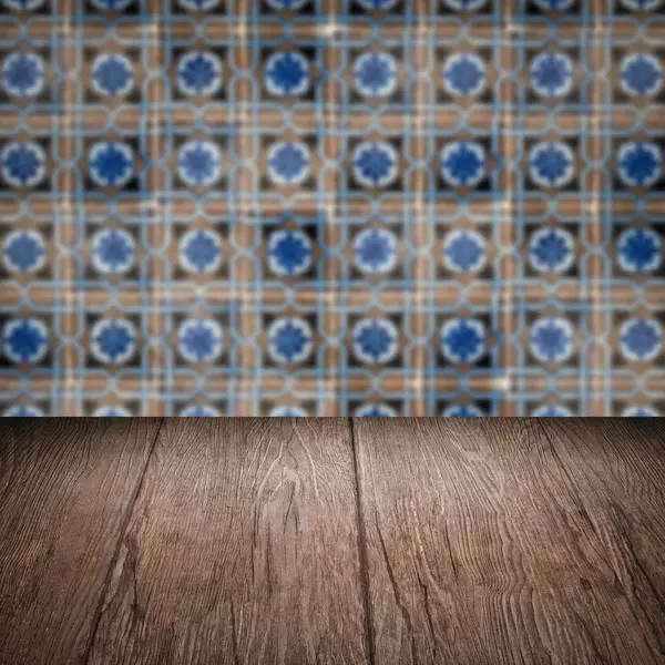 Wood table top and blur vintage ceramic tile pattern wall — Stock Photo, Image