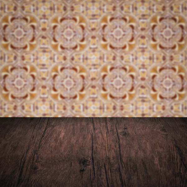 Wood table top and blur vintage ceramic tile pattern wall — Stock Photo, Image