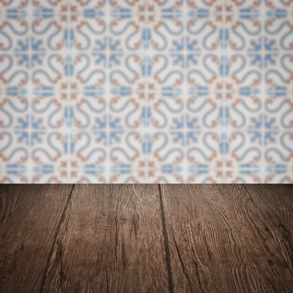 Wood table top and blur vintage ceramic tile pattern wall — Stock Photo, Image