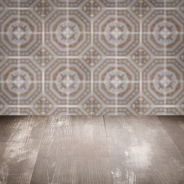 Wood table top and blur vintage ceramic tile pattern wall — Stock Photo, Image