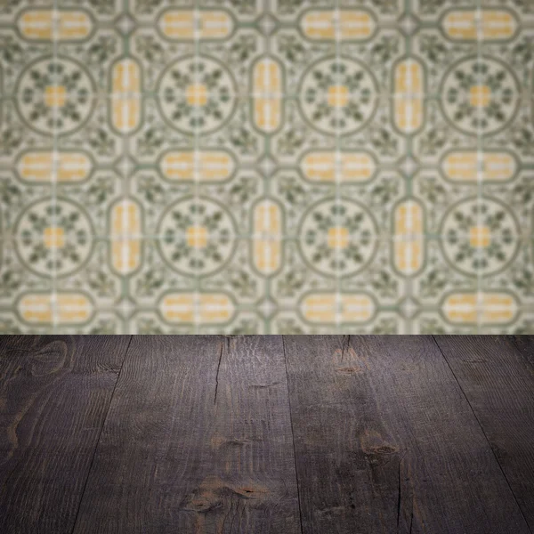 Wood table top and blur vintage ceramic tile pattern wall — Stock Photo, Image