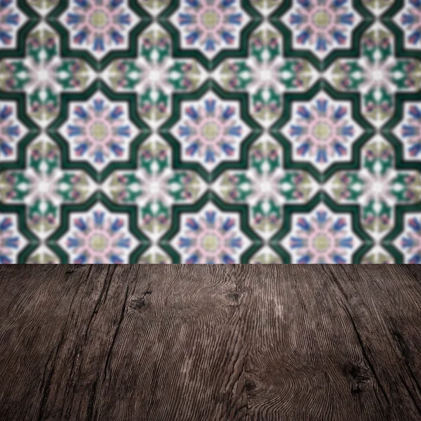 Wood table top and blur vintage ceramic tile pattern wall — Stock Photo, Image