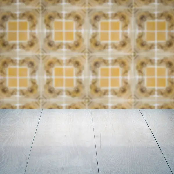 Wood table top and blur vintage ceramic tile pattern wall — Stock Photo, Image