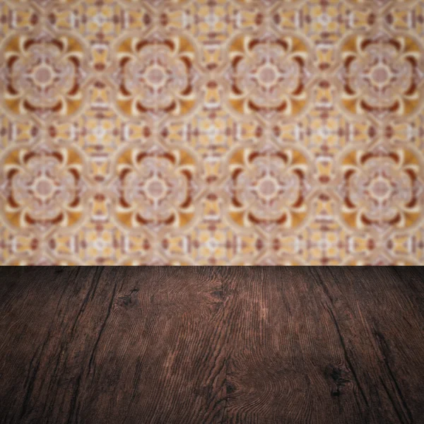 Wood table top and blur vintage ceramic tile pattern wall — Stock Photo, Image