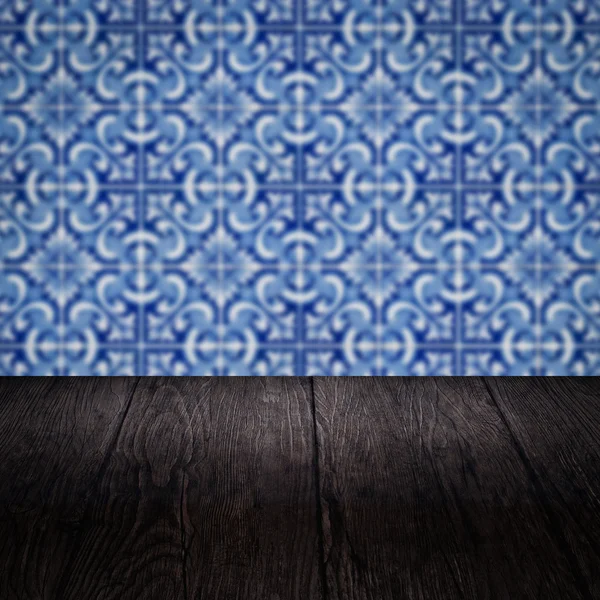 Wood table top and blur vintage ceramic tile pattern wall — Stock Photo, Image