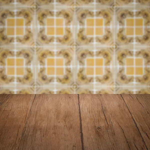 Wood table top and blur vintage ceramic tile pattern wall — Stock Photo, Image