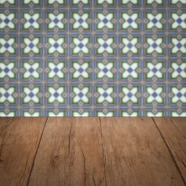 Wood table top and blur vintage ceramic tile pattern wall — Stock Photo, Image