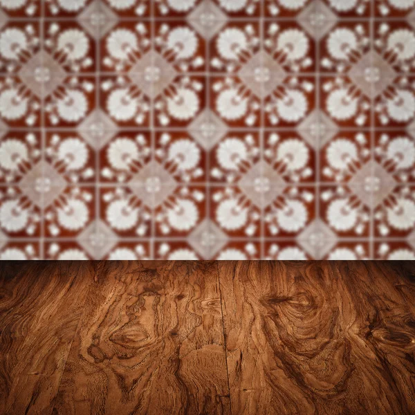 Wood table top and blur vintage ceramic tile pattern wall — Stock Photo, Image