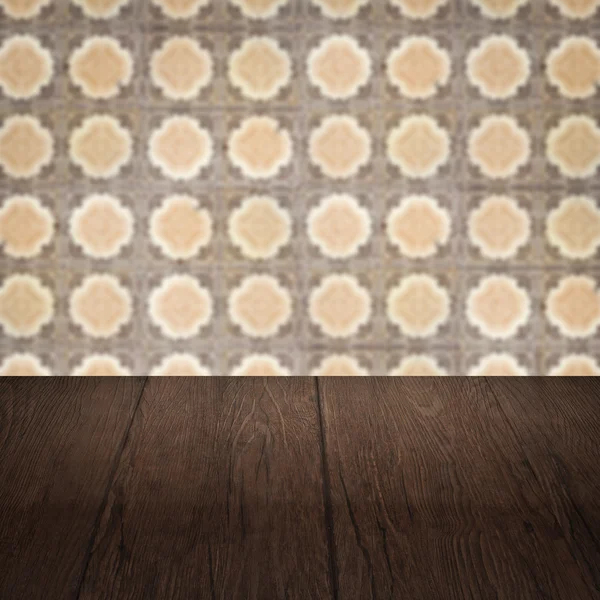 Wood table top and blur vintage ceramic tile pattern wall — Stock Photo, Image