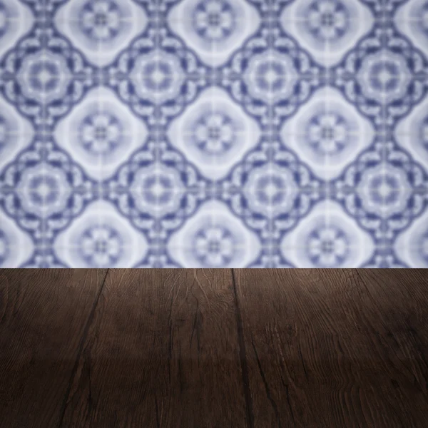 Wood table top and blur vintage ceramic tile pattern wall — Stock Photo, Image