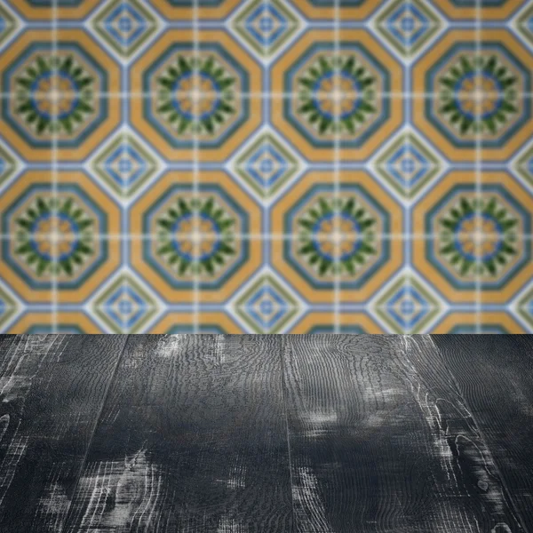 Wood table top and blur vintage ceramic tile pattern wall — Stock Photo, Image