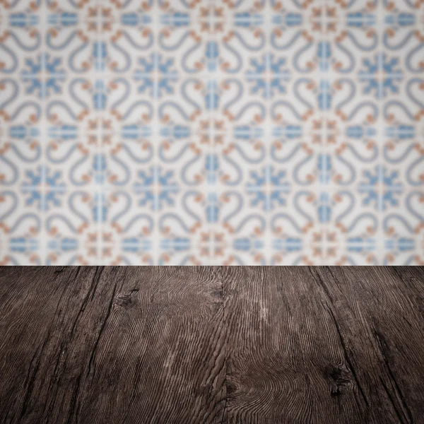 Wood table top and blur vintage ceramic tile pattern wall — Stock Photo, Image