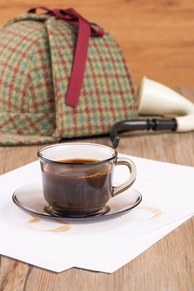 Filiżanka kawy, arkusze papieru i kapelusz detektywa — Zdjęcie stockowe