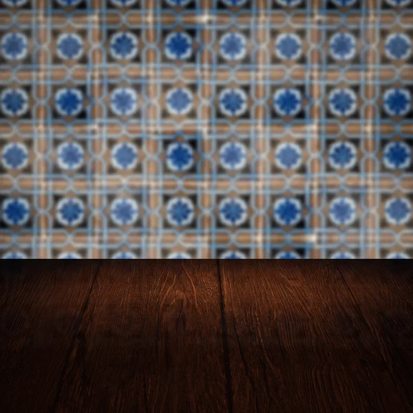 Wood table top and blur vintage ceramic tile pattern wall — Stock Photo, Image