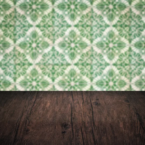 Wood table top and blur vintage ceramic tile pattern wall — Stock Photo, Image