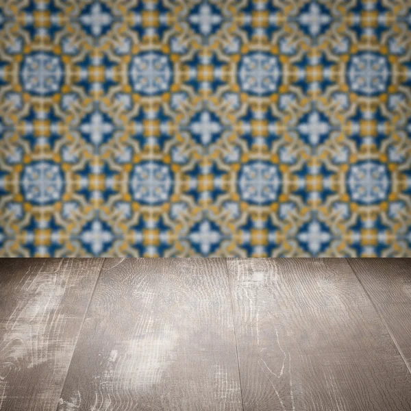 Wood table top and blur vintage ceramic tile pattern wall — Stock Photo, Image