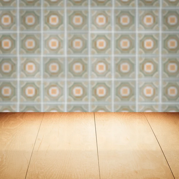 Wood table top and blur vintage ceramic tile pattern wall — Stock Photo, Image