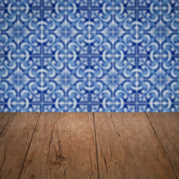 Wood table top and blur vintage ceramic tile pattern wall — Stock Photo, Image