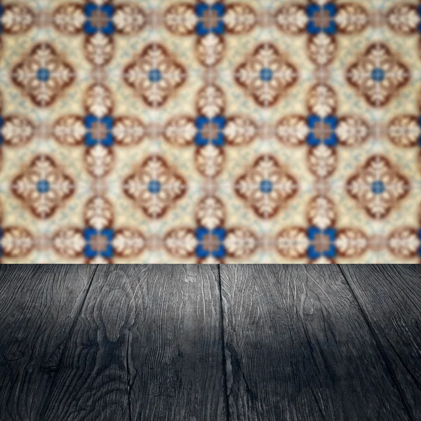 Wood table top and blur vintage ceramic tile pattern wall — Stock Photo, Image