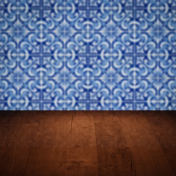 Wood table top and blur vintage ceramic tile pattern wall — Stock Photo, Image