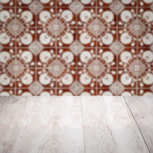 Wood table top and blur vintage ceramic tile pattern wall — Stock Photo, Image