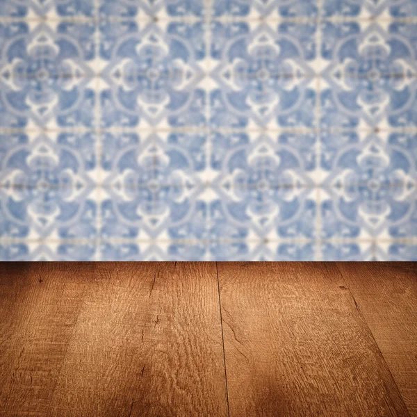 Wood table top and blur vintage ceramic tile pattern wall — Stock Photo, Image