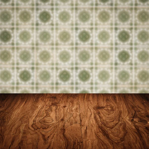 Wood table top and blur vintage ceramic tile pattern wall — Stock Photo, Image