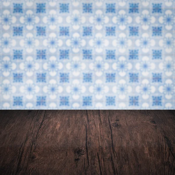 Wood table top and blur vintage ceramic tile pattern wall — Stock Photo, Image