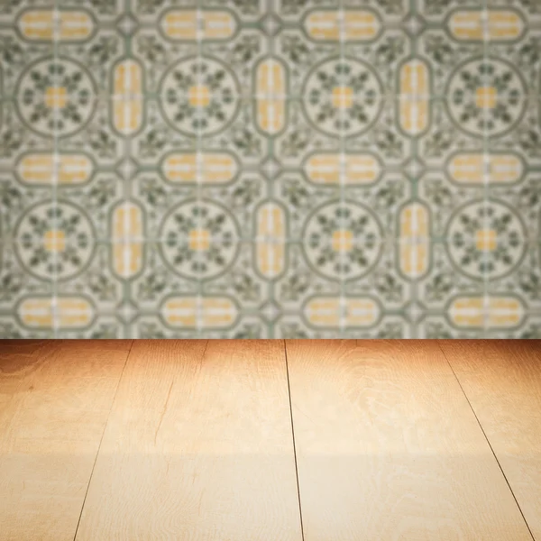 Wood table top and blur vintage ceramic tile pattern wall — Stock Photo, Image