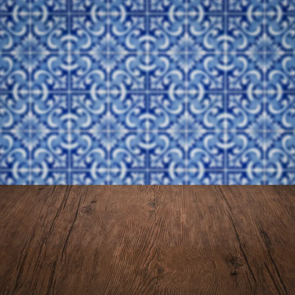 Wood table top and blur vintage ceramic tile pattern wall — Stock Photo, Image