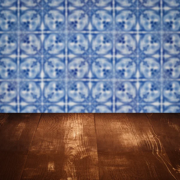 Wood table top and blur vintage ceramic tile pattern wall — Stock Photo, Image