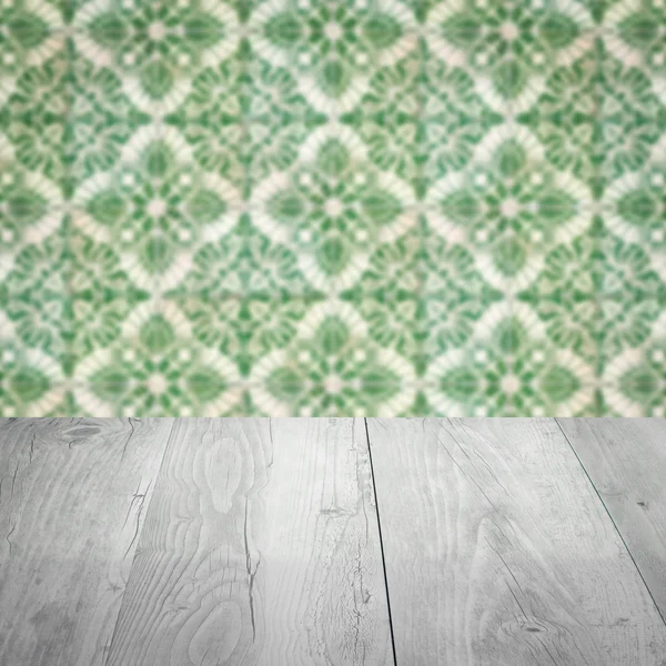 Wood table top and blur vintage ceramic tile pattern wall — Stock Photo, Image