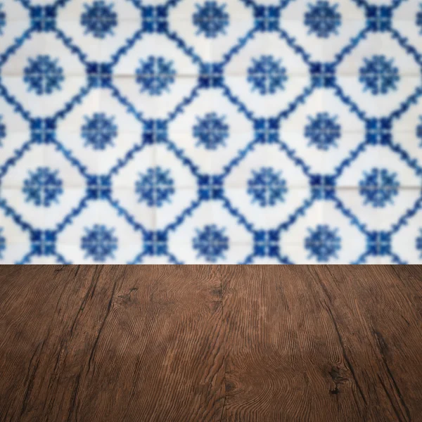 Wood table top and blur vintage ceramic tile pattern wall — Stock Photo, Image