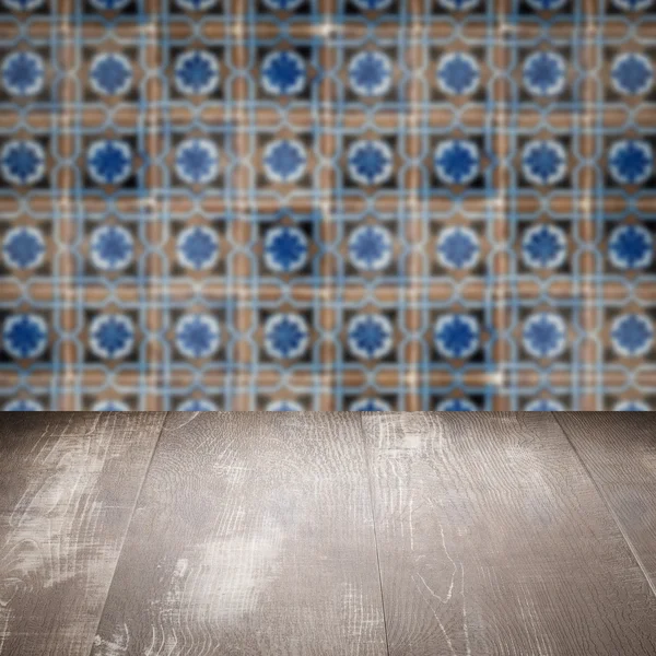 Wood table top and blur vintage ceramic tile pattern wall — Stock Photo, Image