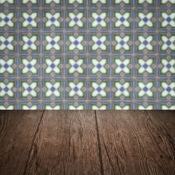 Wood table top and blur vintage ceramic tile pattern wall — Stock Photo, Image