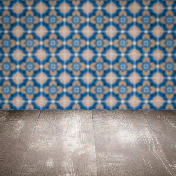 Wood table top and blur vintage ceramic tile pattern wall — Stock Photo, Image