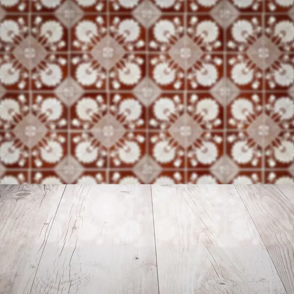 Wood table top and blur vintage ceramic tile pattern wall — Stock Photo, Image