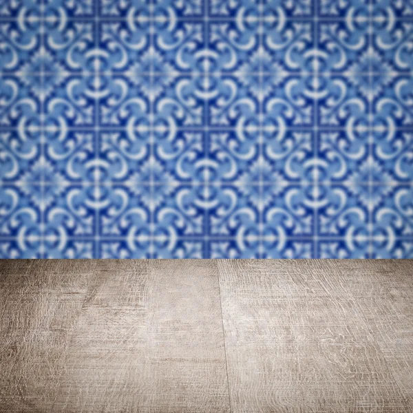 Wood table top and blur vintage ceramic tile pattern wall — Stock Photo, Image