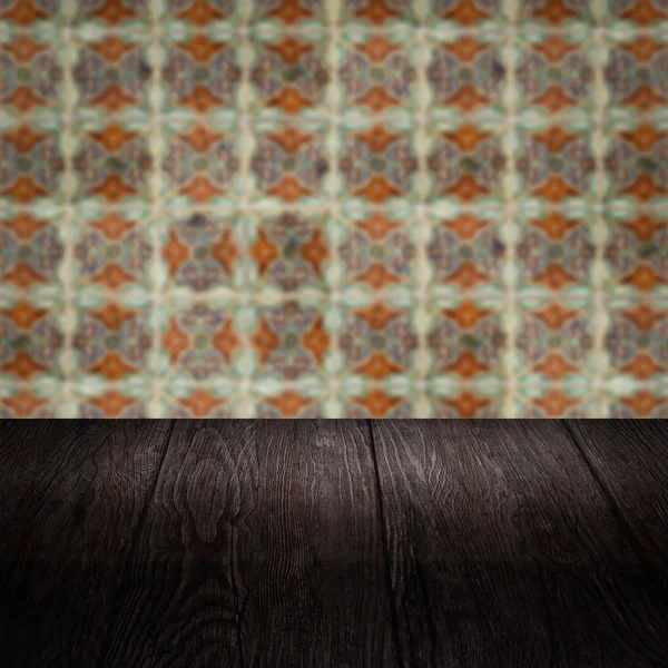 Wood table top and blur vintage ceramic tile pattern wall — Stock Photo, Image