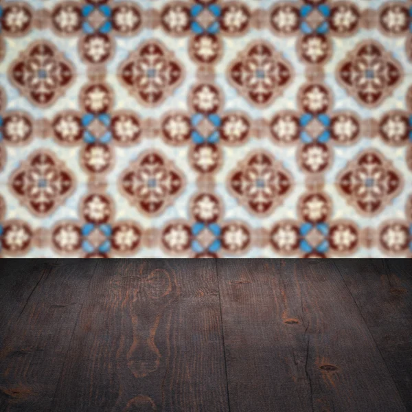 Wood table top and blur vintage ceramic tile pattern wall — Stock Photo, Image