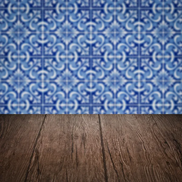 Wood table top and blur vintage ceramic tile pattern wall — Stock Photo, Image